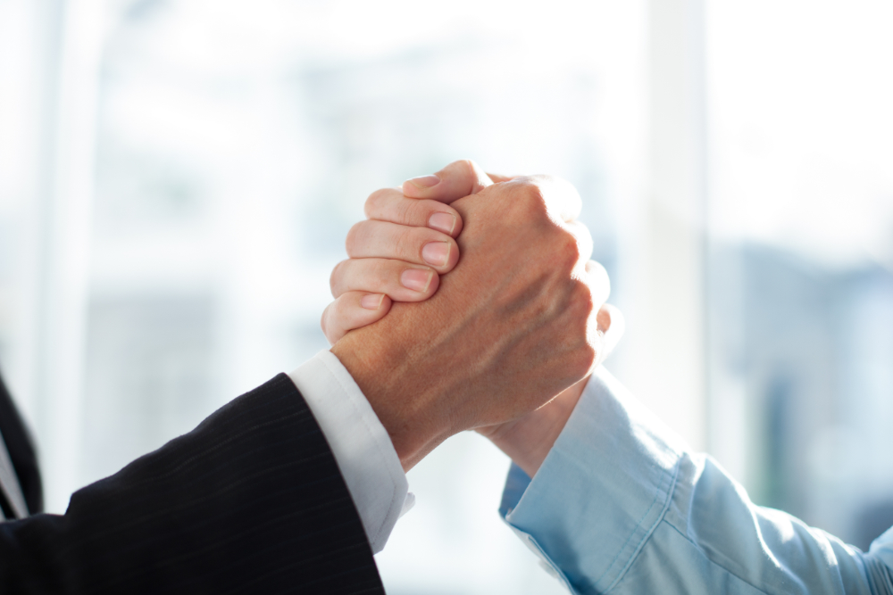Home close up of two clasped hands of businessmen
