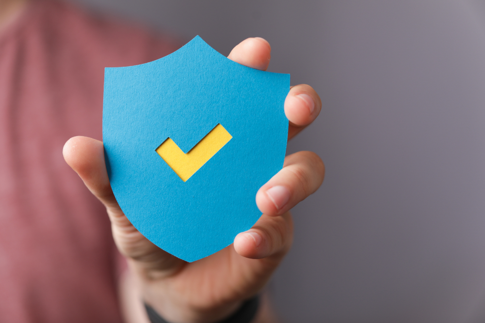 Home sign of the checkmark made of paper in the hands of a man
